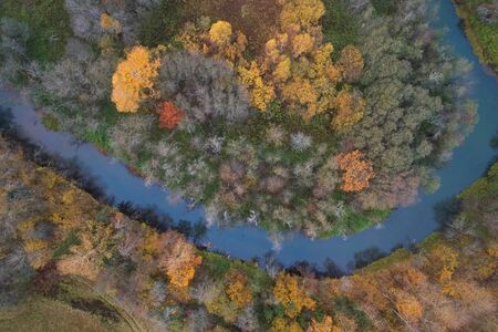 Aerial view with a drone. Winding river with autumn forest, top view.の写真素材