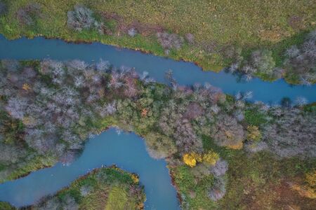 Aerial view with a drone. Winding river with autumn forest, top view.