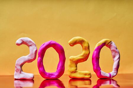 2020 New year design concept. Colored figures of plasticine on a yellow background.の写真素材