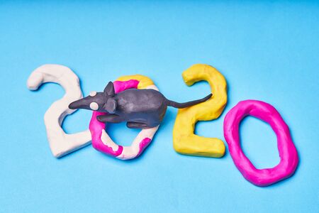 2020 New year design concept with the symbol of the year rat. Colored figures of plasticine on a blue background.の写真素材