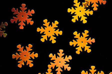 Orange snowflakes on a black background. Christmas background.の写真素材
