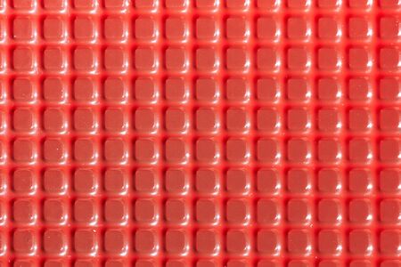 Texture with square red elements. Plastic candy lining.の写真素材