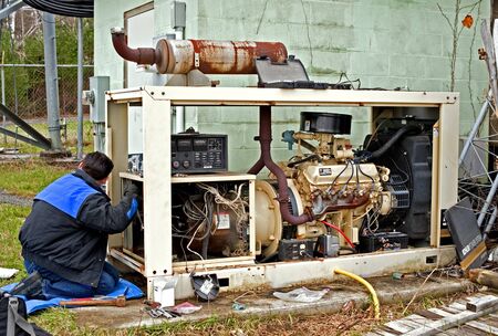 Amesbury, USA - April 1, 2010: Technician repaires an old industrial generator.