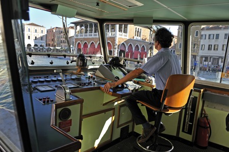 Water taxi driver is steering his boat along the main canal in Veniceのeditorial素材