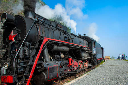 Irkutsk, Russia - August 30, 2016: a retro steam train takes tourists for a journey by the Circum-Baikal Railway, a historic rail road. The Circum-Baikal is one of the picturesque sights of the area aのeditorial素材