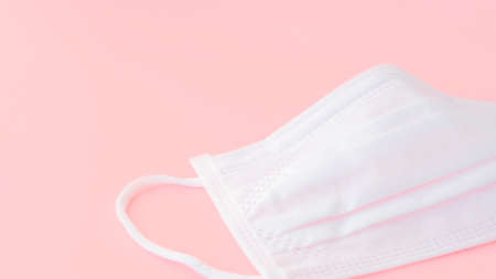 Surgical Face Mask, infection control concept. Mask to prevent colds, virus, pollen, pollution. Coronavirus, flu, PM2.5. Pastel pink background.の写真素材