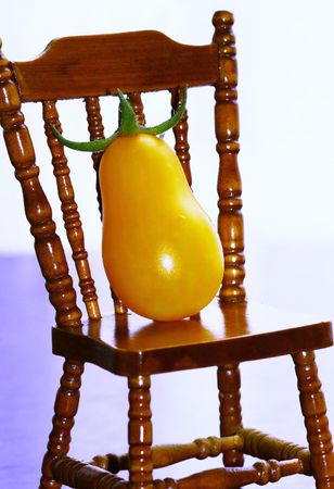 Mini yellow tomatoes sitting in a chairの写真素材