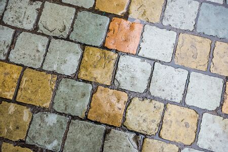 Wet from the rain colorful brick tiles diagonal background texture.の写真素材