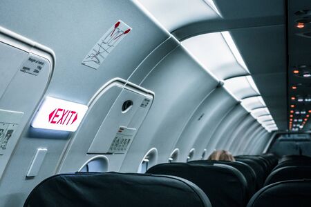 Inside the aircraft. The exit sign and cabin lights.