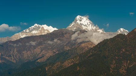 GHOREPANI, NEPAL - JANUARY 9, 2025: Beauty of Annapurna range mountains, view from Ghorepani, warm golden hour light casts a serene glow over stunning landscape.の写真素材