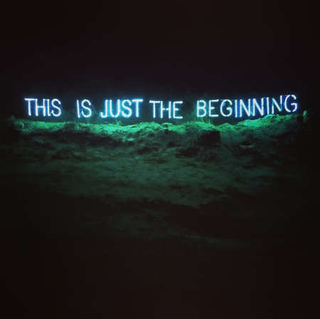 Motivational illuminated signage, neon word text, "this is just the beginning", on the landscape, during night.の写真素材