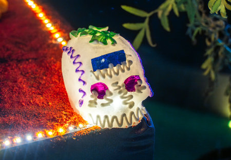 A skull with purple and blue decorations is sitting on a table. The skull is decorated with purple...