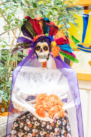 A skeleton is dressed in a purple veil and a flower garland, giving it a festive and colorful...