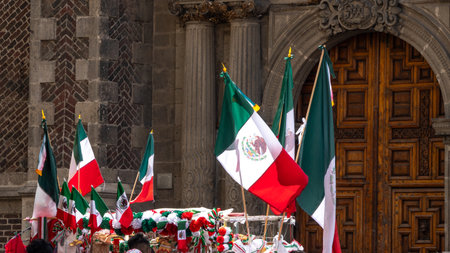 A group of flags are hanging from a building. The flags are red, white, and green. Decoration to...