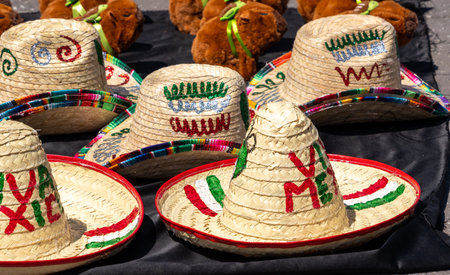 A collection of hats with the word "Viva Mexico" written on them. The hats are displayed on a black table. Decoration to celebrate Independence Day in Mexico, zocaloの写真素材
