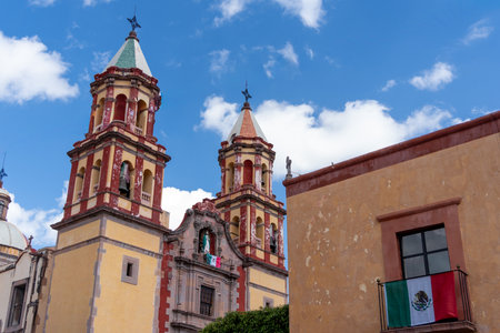 A historic building with two tall towers and a large window. The building is situated in a peaceful....
