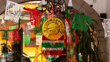 A vibrant and lively scene with a large, gold and green banner hanging in front of a building. Historic center of Queretaro, colonial architecture, decorations for the celebration of Mexico's Independence Day.の写真素材