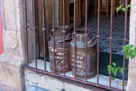 Two old metal cans with the words written on them. Historic center of Queretaro, colonial architecture, decorations for the celebration of Mexico's Independence Day.の写真素材