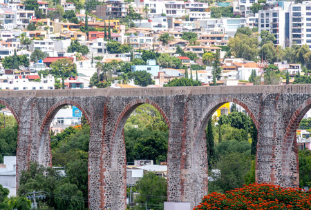 A bridge with arches is seen in the distance, with a city in the background. The bridge is old. Historic center of Querétaro, colonial architecture, decorations for the celebration.の写真素材