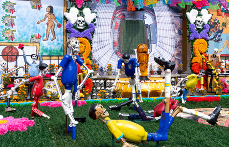 A group of skeletons are playing soccer on a field. The skeletons are dressed in blue. Mexican Day of the Dead tradition, offerings, food, colors, decorations, and papel picado, La Catrina.の写真素材