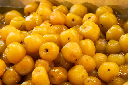 A bunch of yellow fruit with a sticky substance on them. The fruit is in a bowl.の写真素材