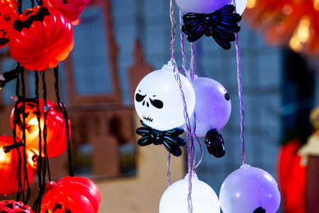 A string of Halloween lights with skulls and bones hanging from it. The lights are red, white. Mexican Day of the Dead tradition, offerings, food, colors, decorations, and papel picado.の写真素材