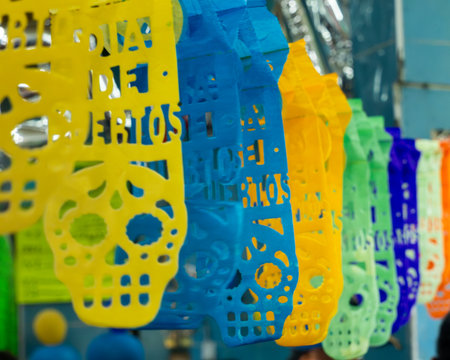 A vibrant and lively display of paper cutouts in various colors and shapes, all arranged in a way th. Mexican Day of the Dead tradition, offerings, food, colors, decorations, and papel picado, La Catrina.の写真素材