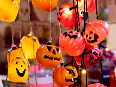 A bunch of Halloween pumpkins hanging from the ceiling. The pumpkins are orange.の写真素材