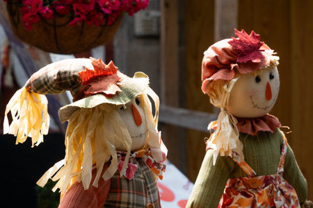 Two scarecrows with hats and fake leaves on their heads. One is smiling and the other is frowning. Mexican Day of the Dead tradition, offerings, colors, decorations, and papel picado, La Catrina.の写真素材