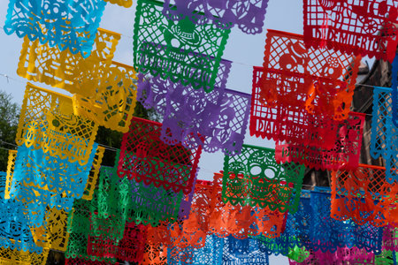 A vibrant display of colorful paper decorations with the word Dia written on them. Mexican Day of the Dead tradition, offerings, food, colors, decorations, and papel picado, La Catrina.の写真素材