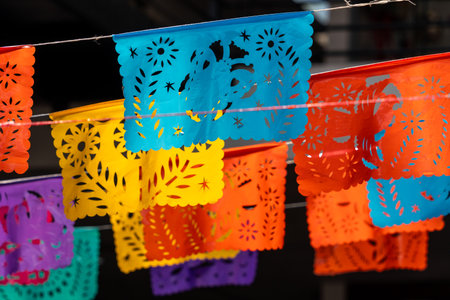 A bunch of colorful paper lanterns with various designs, including flowers and stars, are hanging. Mexican Day of the Dead tradition, offerings, food, colors, decorations, and papel picado.の写真素材