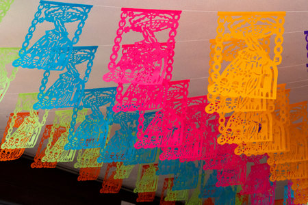 A vibrant display of paper lanterns, each one featuring a woman on it. Mexican Day of the Dead tradition, offerings, food, colors, decorations, and papel picado, La Catrina.の写真素材
