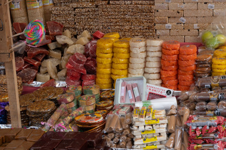 A colorful display of food items, including candy and pastries, is arranged on a table. Mexican Day of the Dead tradition, offerings, food, colors, decorations, and papel picado, La Catrina.の写真素材