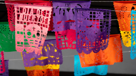 A bunch of colorful paper lanterns with the word Dia de Muertos written on them are hanging from a l. Mexican Day of the Dead tradition, offerings, food, colors, decorations, and papel picado, La Catrina.の写真素材