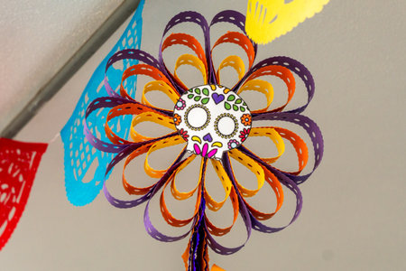A vibrant and whimsical paper flower with a skull in the center. Mexican Day of the Dead tradition, offerings, food, colors, decorations, and papel picado, La Catrina.の写真素材