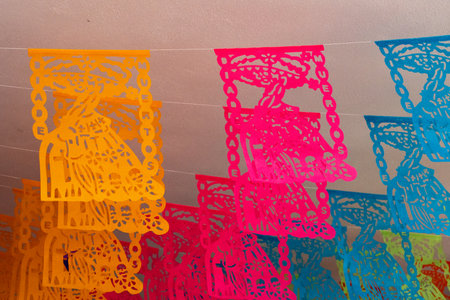 A colorful display of paper lanterns with a variety of shapes and sizes. The colors are bright. Mexican Day of the Dead tradition, offerings, food, colors, decorations, and papel picado, La Catrina.の写真素材