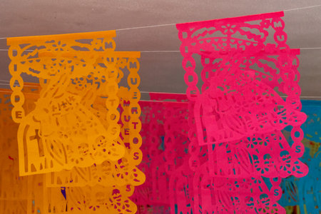 A vibrant display of paper lanterns. Mexican Day of the Dead tradition, offerings, food, colors, decorations, and papel picado, La Catrina.の写真素材