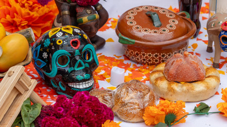 A table with a skull, bread, and other items. The skull is decorated with flowers. Mexican Day of the Dead tradition, offerings, food, colors, decorations, and papel picado, La Catrina.の写真素材
