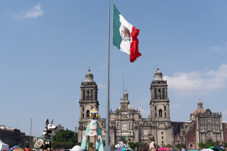 A large flag is flying in front of a large building. The flag is red and green. Mexican tradition, offerings, food, colors, decorations, and papel picado, La Catrina.の写真素材