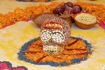 A skull made of beans and other food items is displayed on a table with various other food items. Mexican Day of the Dead tradition, offerings, food, colors, decorations, and papel picado, La Catrina.の写真素材
