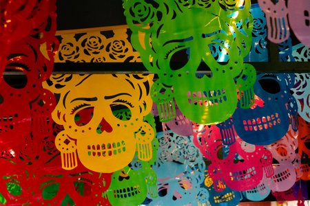 A vibrant collection of paper skulls, each with a unique design and color scheme, are arranged in a . Mexican Day of the Dead tradition, offerings, food, colors, decorations, and papel picado, La Catrina.の写真素材