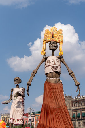 Two skeletons are dressed in vibrant clothing, including a crown and a skirt. Mexican Day of the Dead tradition, offerings, food, colors, decorations, and papel picado.の写真素材