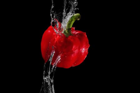 Red pepper in water streamの写真素材