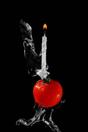 Tomato and candle in water streamの写真素材