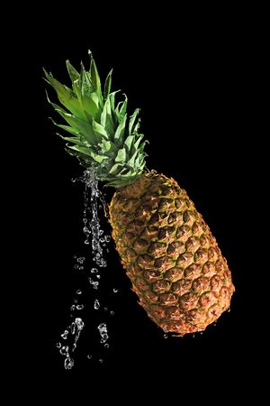 Whole pineapple with drops of waterの写真素材