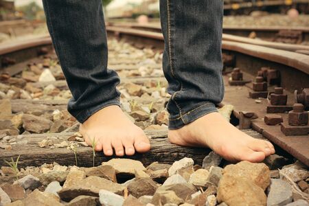 Bare feet on the railway station - railroad.の写真素材