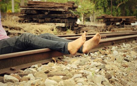 Bare feet on the railway station - railroad.の写真素材