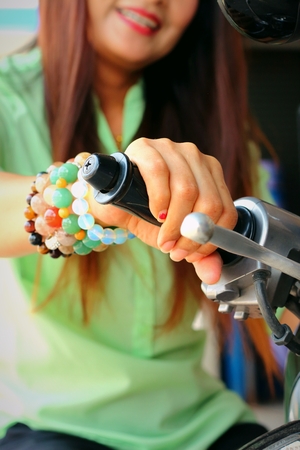 Women wear bracelets handle Motorcycles in parking.の写真素材