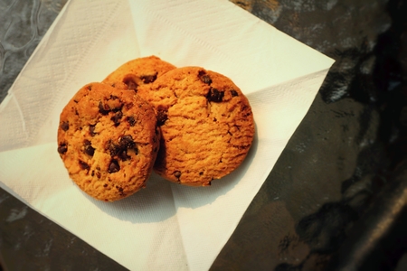 Chocolate chip cookies on white background and table .