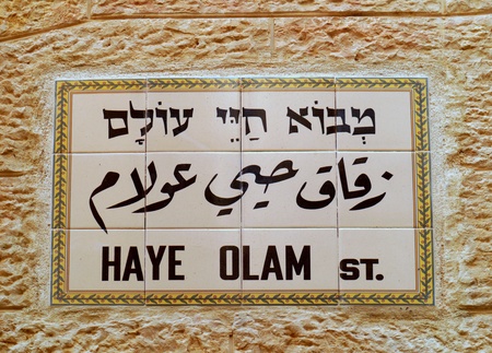 Jerusalem, Israel, October 2011 - street sign in the Old City, it consists of ceramic tiles embedded in the stone wall of a building, trilingual in Hebrew, Arabic, and English characters.  The name of this street means "Eternal Life"のeditorial素材